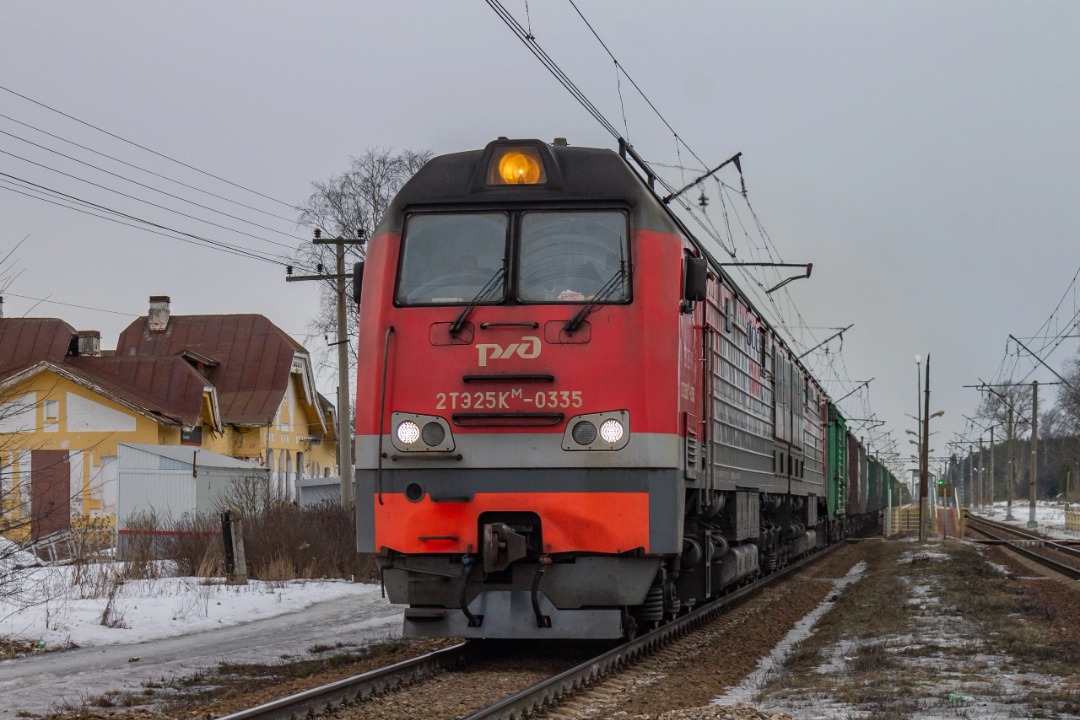 Vladislav on Train Siding: diesel locomotive 2TE25KM-0335 with a freight train on the Semrino - Vyritsa stage. in the background, the historic station building
of the...