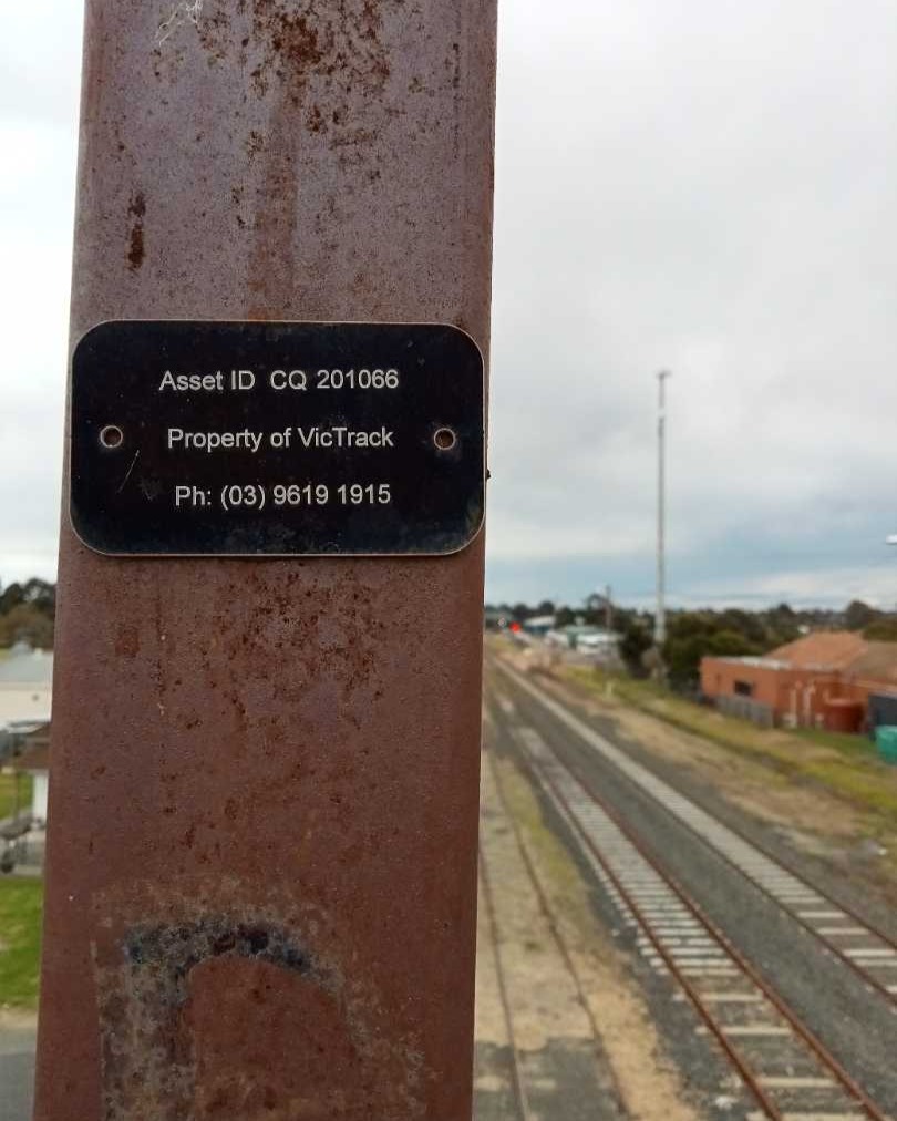 Ethans Transport Vlogs on Train Siding: Property of VicTrack sign on the pedestrian overpass at Bairnsdale and warning signs at a gate to go onto the tracks.