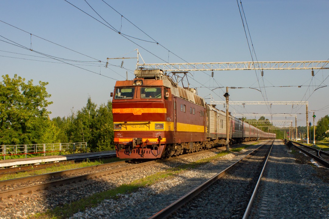 CHS200-011 on Train Siding: Electric locomotive ChS4T-256 flies with a passenger train at Prosnitsa station towards Balezino from Kirov in the rays of the
morning sun.