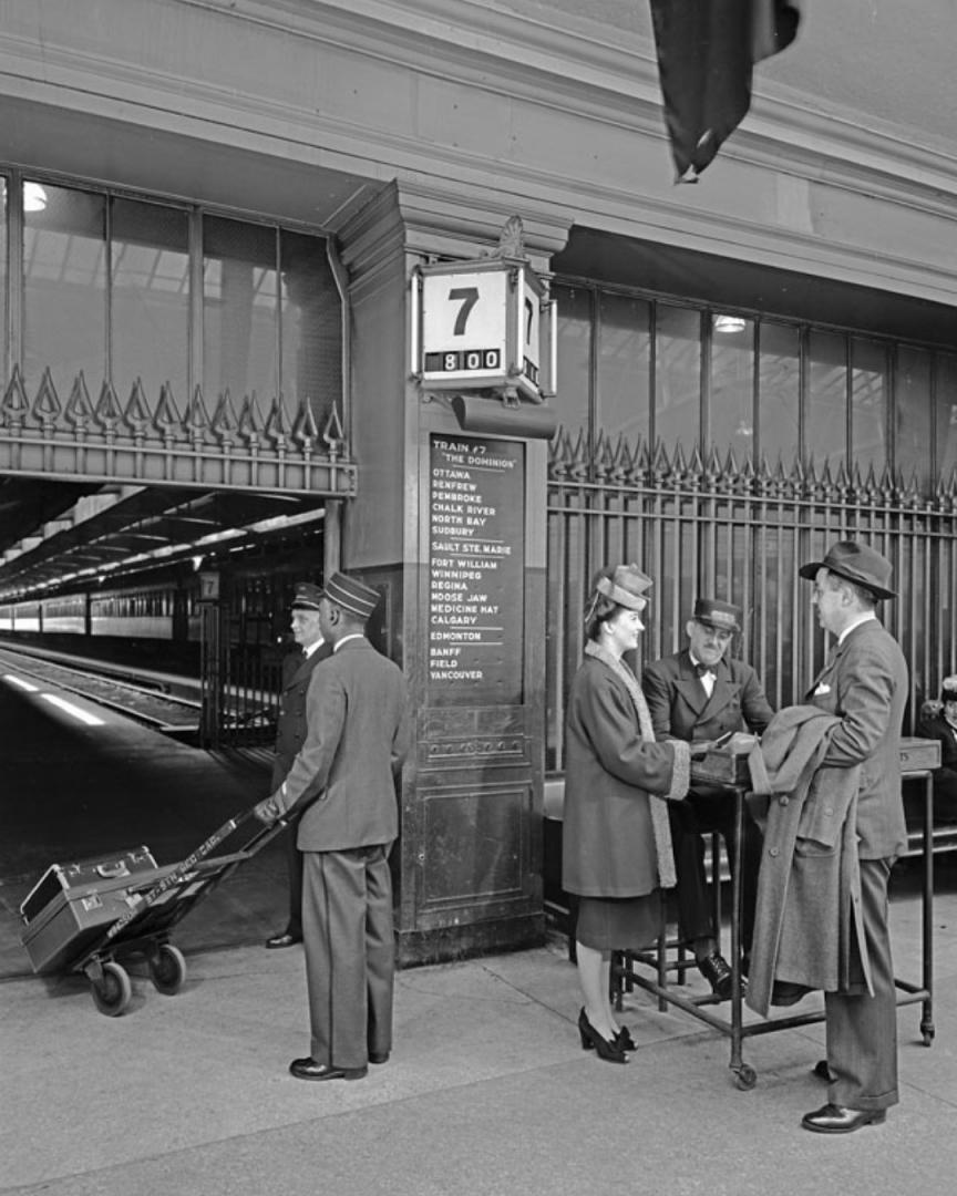 All Aboard! on Train Siding: A porter takes luggage for passengers about to board “The Dominion” at Windsor Station, Montréal, Quebec, circa
1947