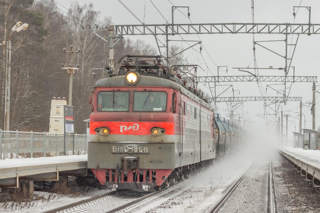 CHS200-011 on Train Siding: Electric locomotive VL10-1868 follows with a liquid freight train along the Mga - Gory section, passing the platform "stopping
point 45 km"